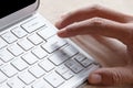 Close-up of male forefinger on button of silver color keyboard o