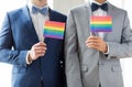 Close up of male gay couple holding rainbow flags