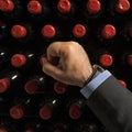 Close-up Male hand bottled wine wine. several bottles of wine in row in cellars of winery or restaurant. Royalty Free Stock Photo