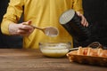 Close up of male hand dropping flour in a bowl with beaten egg