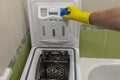 A man`s hand pours powder into a top-loading washing machine