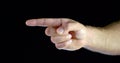 Close - up male hand gesture with index finger towards black isolated background.