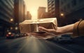 Close up of male hand holding gift box on blurred city street background Royalty Free Stock Photo