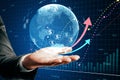 Close up of male hand holding glowing globe, financial arrows and money signs on blurry background. Digital world, cryptocurrency Royalty Free Stock Photo