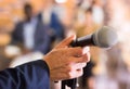 Male hand holding microphone at conference hall Royalty Free Stock Photo