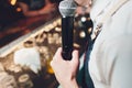Close up male hand holding microphone. in the interior of the bar. Royalty Free Stock Photo