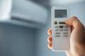 Close-up of male hand holding remote control of air conditioner. Royalty Free Stock Photo