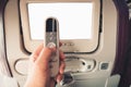 Close up male hand is holding remote control of LCD screen monitor in an airplane seat for passengers entertainment Royalty Free Stock Photo