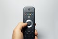 Close-up of male hand holding tv remote on white background. Royalty Free Stock Photo