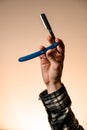 Close-up of male hand masterfully holding classic old straight razor Royalty Free Stock Photo