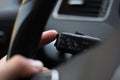 Close-up of male hand pushes cruise control button.