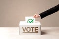 Close up of male hand putting vote into a ballot box