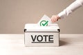 Close up of male hand putting vote into a ballot box