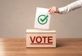 Close up of male hand putting vote into a ballot box