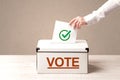 Close up of male hand putting vote into a ballot box