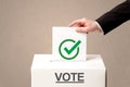 Close up of male hand putting vote into a ballot box