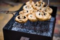 Close-up male hand reverses champignon while grilling mushrooms over flaming charcoal. Barbecue Barbeque BBQ grill party