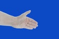 Close up of male hand showing handshaking gesture, isolated on blue. Stretching open palm for giving handshake, hello, nice to