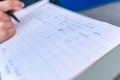 Close-up male hand taking feeding note and remarks on a paper with pen Royalty Free Stock Photo