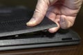 Close-up male hand technician opens the rear compartment of the laptop.