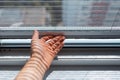 Close-up of male hand trying to open the modern mosquito net on plastic window. Royalty Free Stock Photo