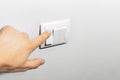 Close-up of male hand, turning on/off the light by electric switch button. Royalty Free Stock Photo