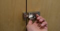 Close-up of male hand turning twist knob to open stainless steel door lock latch Royalty Free Stock Photo