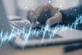 Close up of male hand using laptop at desk with glowing candlestick forex chart on blurry background. Trade, finance and index Royalty Free Stock Photo