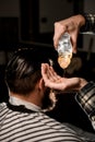 close-up of male hand in which gently pouring hair oil for man. Barber shop Royalty Free Stock Photo