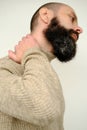 Close-up of male hands on back of neck, young man holds throat, guy with beard 30 years old is sick, concept health, diagnosis and