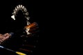 Close-up male hands with badminton racket and shuttlecock isolated over dak studio background with stroboscope effect.