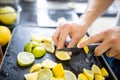 Male hands slicing lemons and limes on a black tray Royalty Free Stock Photo