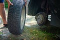 Close up of male hands changing car tire outside. Replacing broken vehicle tire on the grass. Travel accident Royalty Free Stock Photo