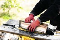 Close up of male hands chopping birch firewood on a hydraulic wood splitter. Sawmill. Birch firewood for fireplac