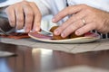 Close up of a male hands cutting food with knife.