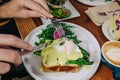 Close-up of male hands cutting with knife delicious toast with poached egg Royalty Free Stock Photo