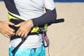 Close up male hands fasten Arnes for kitesurfing on the beach before going to sea. Kiteboarding equipment for kite courses.
