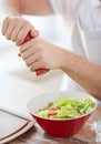 Close up of male hands flavouring salad in a bowl Royalty Free Stock Photo