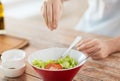 Close up of male hands flavouring salad in a bowl Royalty Free Stock Photo