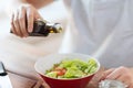 Close up of male hands flavouring salad in a bowl Royalty Free Stock Photo