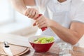 Close up of male hands flavouring salad in a bowl Royalty Free Stock Photo