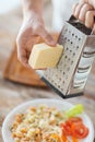 Close up of male hands grating cheese over pasta Royalty Free Stock Photo