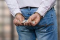 Close up male hands in handcuffs holding money.