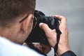 Close up male hands hold professional camera and make a photo