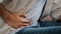 Close-up of male hands holding belly by side unrecognizable man feels bad digestive problems abdominal pain illness