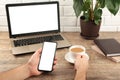 Close up male hands holding big smart phone , businessman using technology sitting at wooden desk Royalty Free Stock Photo