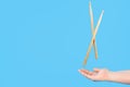 Close up male hands holding drumsticks on an isolated blue background. Concept of drumming lessons