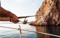 Close up of male hands holding fishing rod while fishing on sailboat in open sea Royalty Free Stock Photo