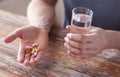 Close up of male hands holding pills and water Royalty Free Stock Photo