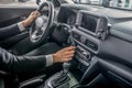 Close-up of male hands holding steering wheel, pressing control buttons